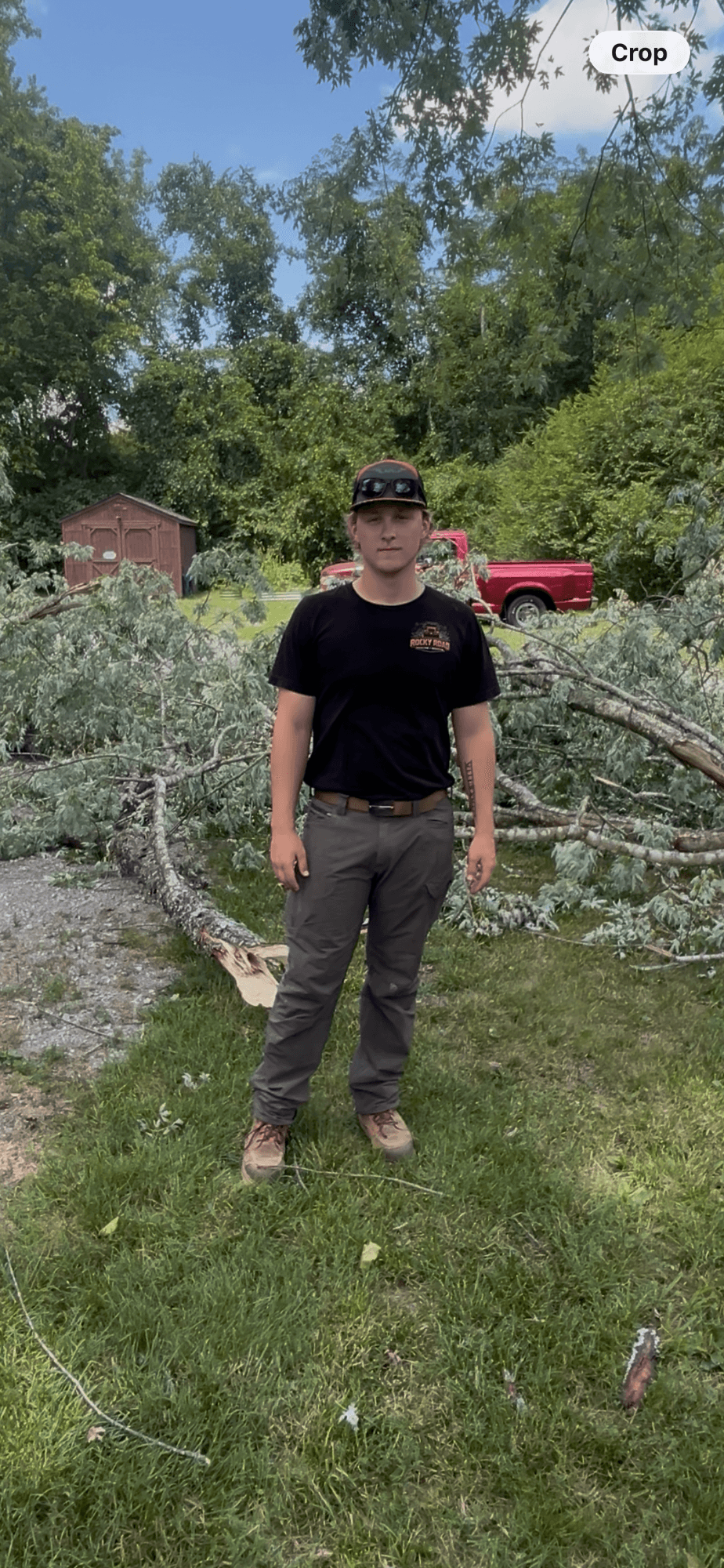 Rocky, founder of Rocky Road Hauling + Removal, standing on a job site in a Rocky Road shirt